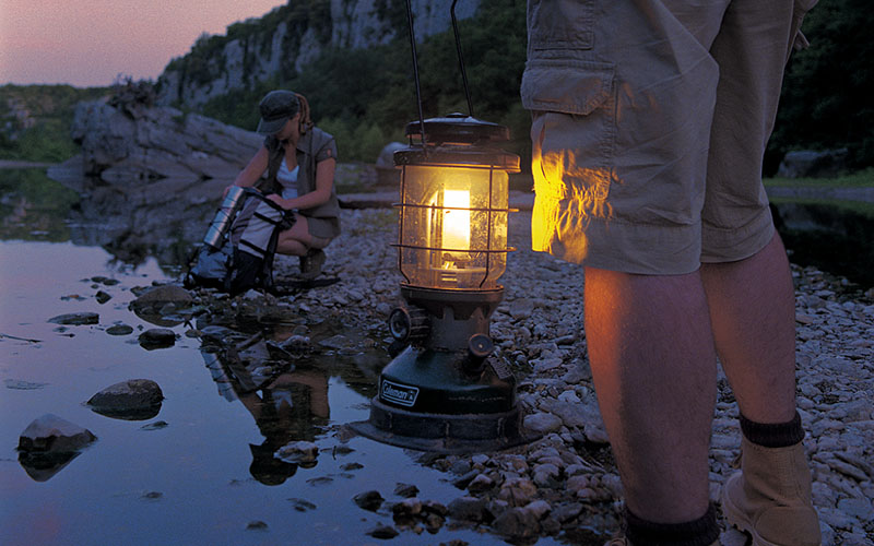 туристи на брега на река с бензинов фенер